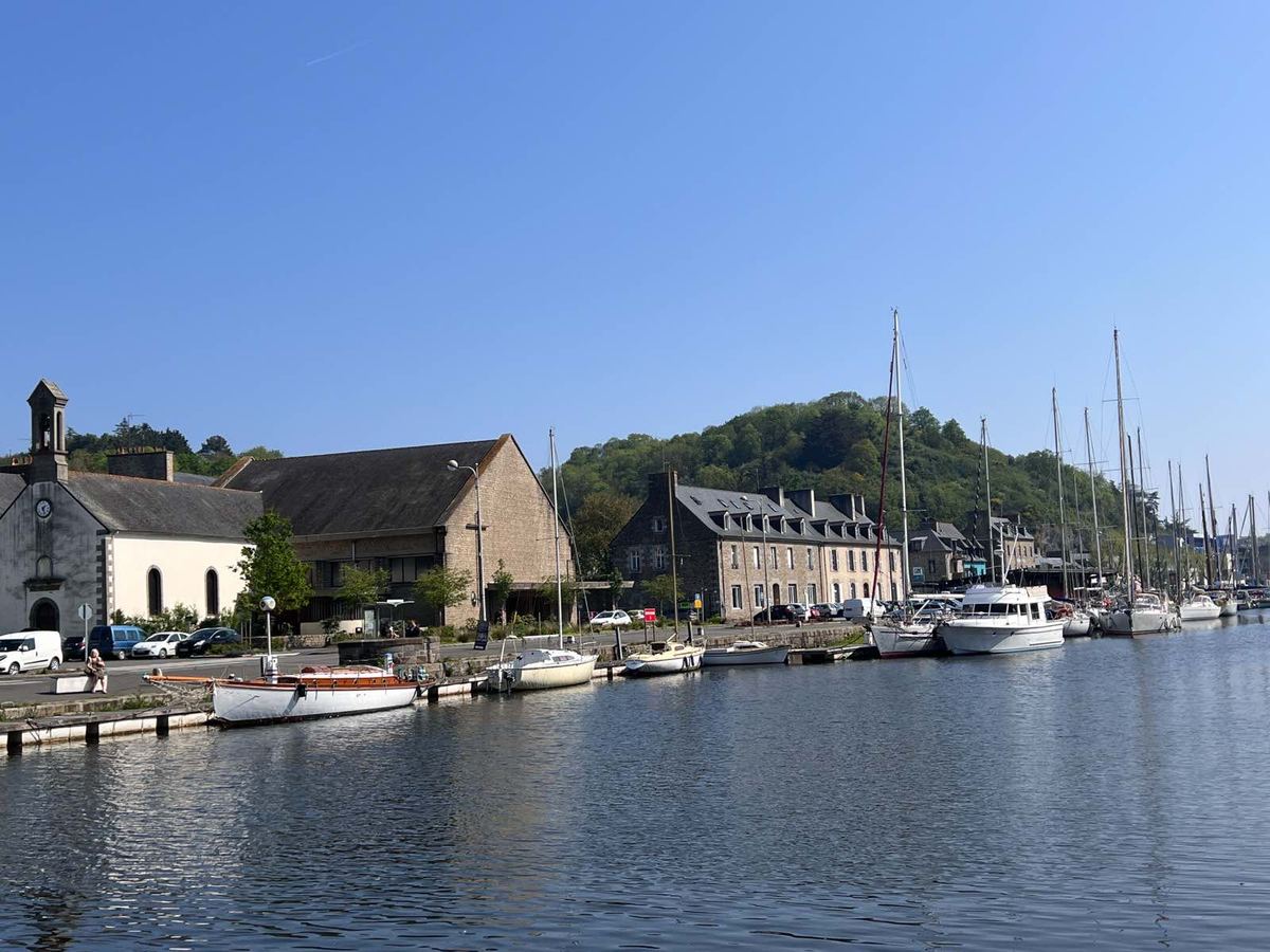 Le port du Légué à Plérin : voiliers à quai devant les maisons de pierre, au pied de la colline boisée